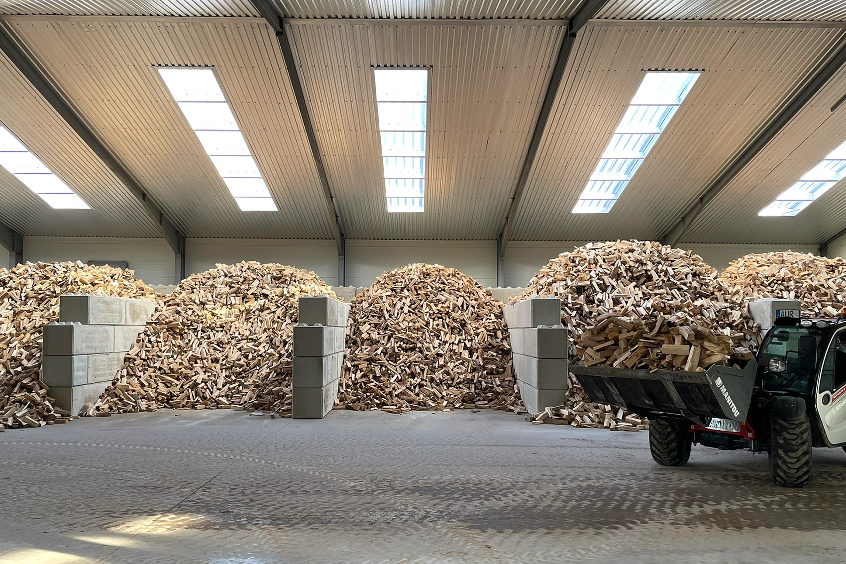 Großes Holzlager mit ofenfertigem Brennholz in Verkaufsboxen
